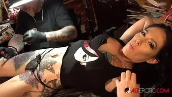 Marie Bossette touches herself while being tattooed