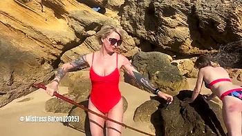 Dona loira chicoteia escravo de biquíni na praia
