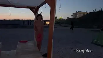 Two naked sluts play with each other in the sea on a public beach